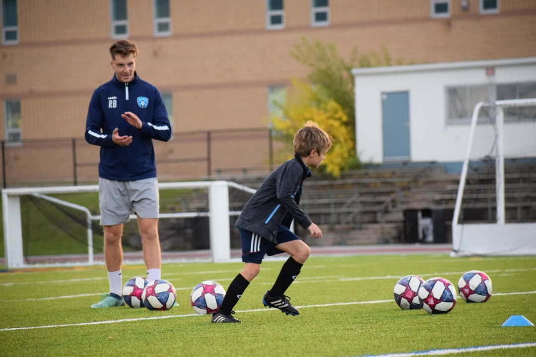 Ryan Bouchard, owner of Optimal Soccer Training, coaching a client through a soccer drill.